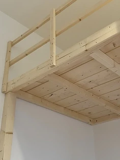 Liegefläche eines Hochbetts von unten, Bretter und Querbalken sichtbar