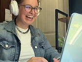Niki laughing while working at her desk, at ease with families