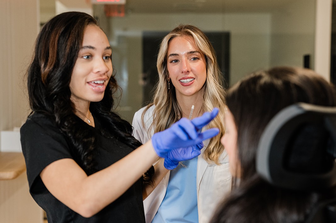 Mackenzie teaching an aesthetic injection technique to a cohort of injectors