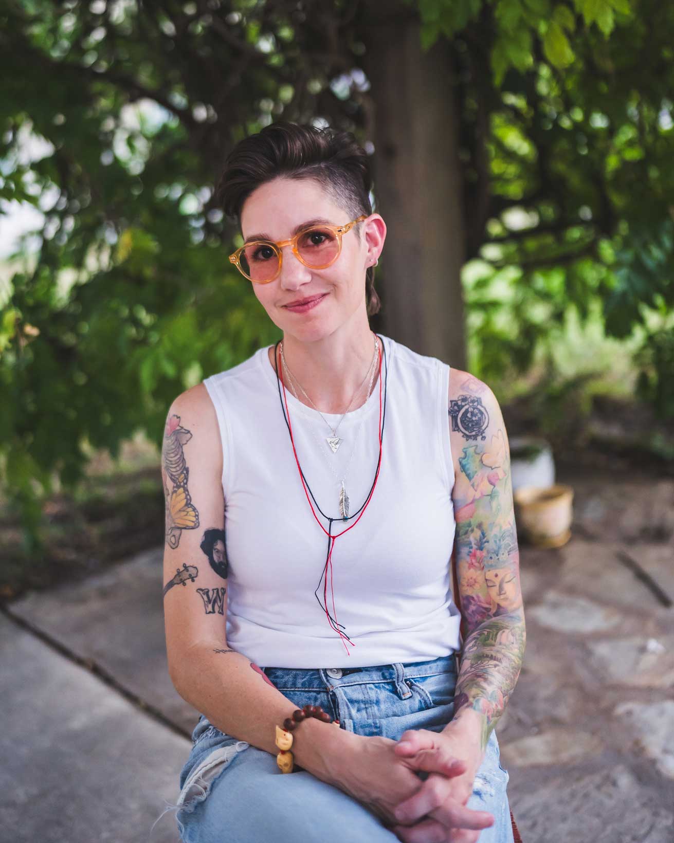 Emily McLoud close-up outdoors with sunglasses and bolo tie, direct gaze