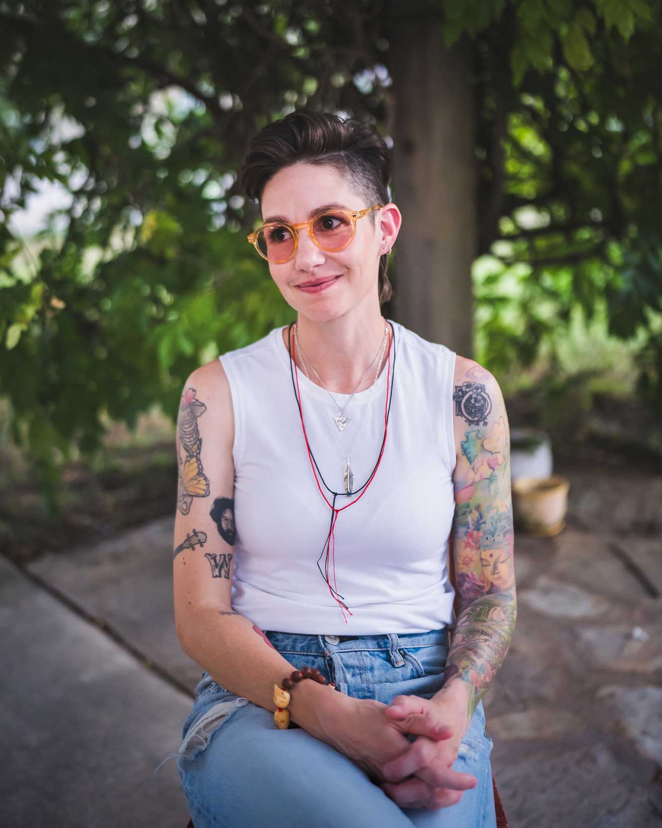 Emily McLoud portrait outdoors in amber sunglasses, looking slightly off camera