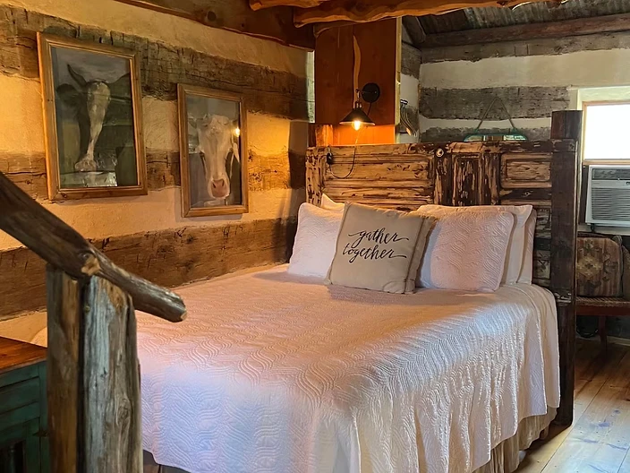Private bedroom with a vintage door headboard and gather together accent pillow at Camp Milagro