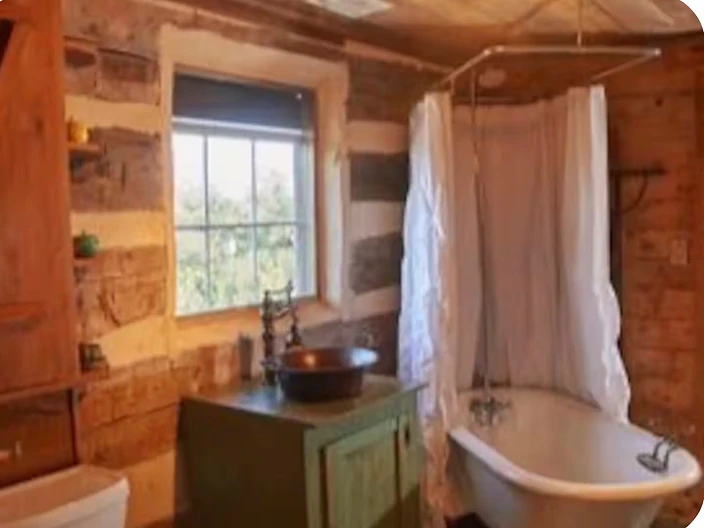 Private bathroom with a copper sink and claw-foot tub at Camp Milagro