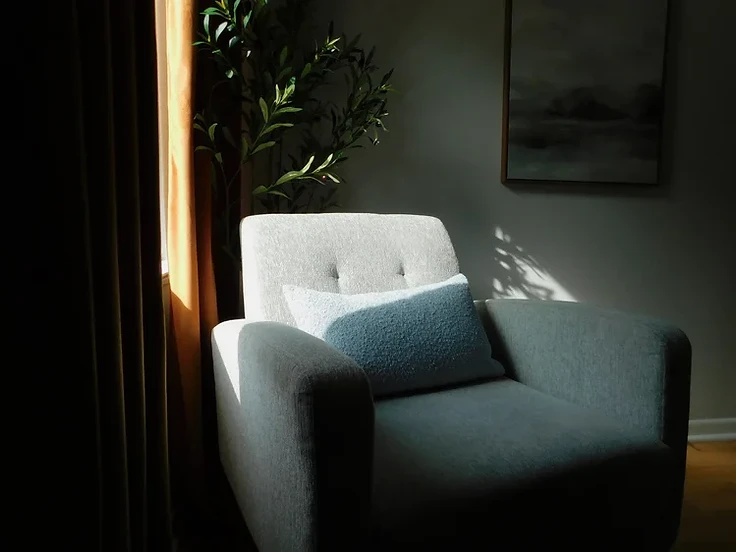 Comfortable armchair with warm lamp light and natural light in a private San Antonio therapy office