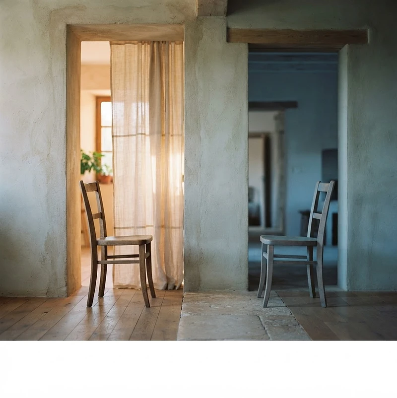 Two chairs positioned in relation to one another in warm, natural light