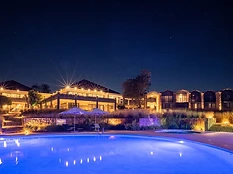 Akagera Game Lodge at night with an illuminated swimming pool overlooking Lake Ihema