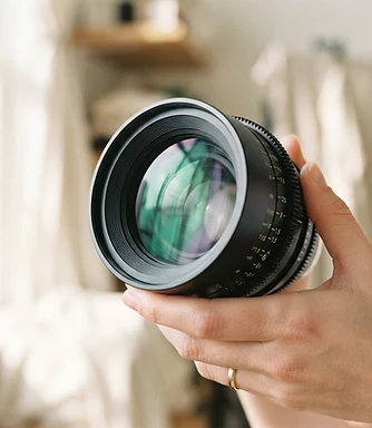 Close-up of a cinema camera lens held in sunlight