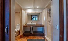 Bathroom with wooden vanity and open shower