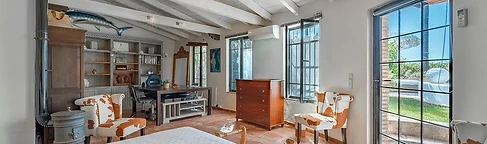 Bedroom with iron stove and cowhide armchairs