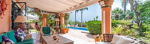 Covered porch with sofas overlooking the pool