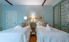 Twin bedroom beneath dark wooden beams