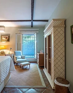Green bedroom with armchair and garden views