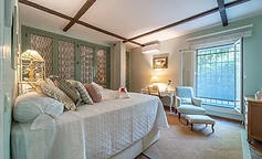 Bedroom with desk, blue armchair and green wardrobe