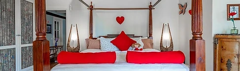 Four-poster bed framed by beams and brick