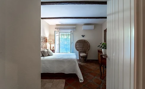 Bedroom with carved headboard and wicker chair