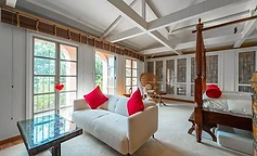 Bright bedroom with four-poster bed and sofa