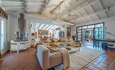 Open living room with white beams and afternoon light