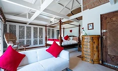 Principal bedroom with white sofa and red cushions