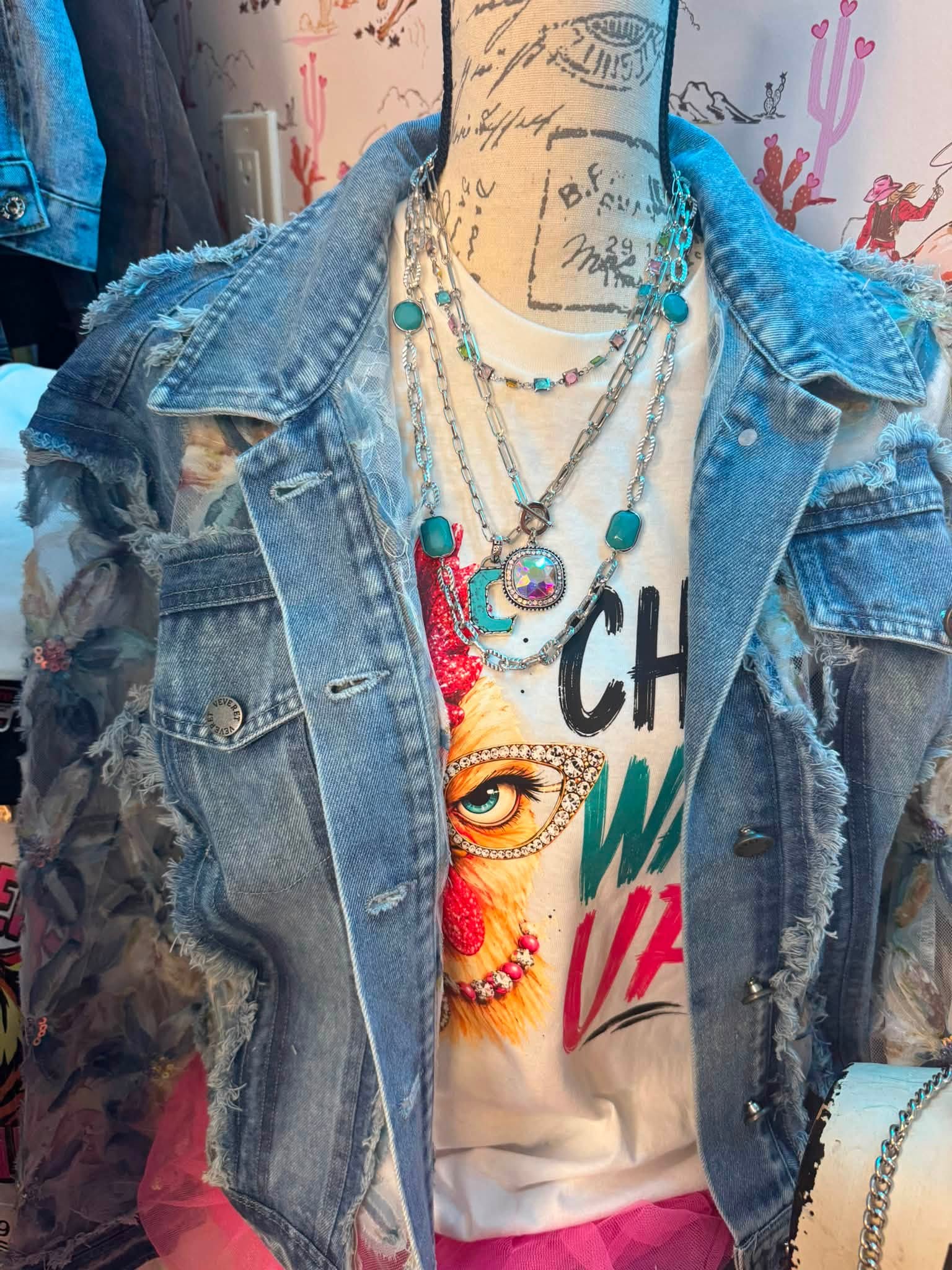 Distressed denim jacket with layered turquoise jewelry
