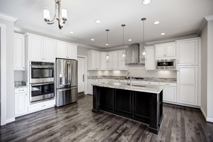 High-end remodeled kitchen with white cabinetry and granite island