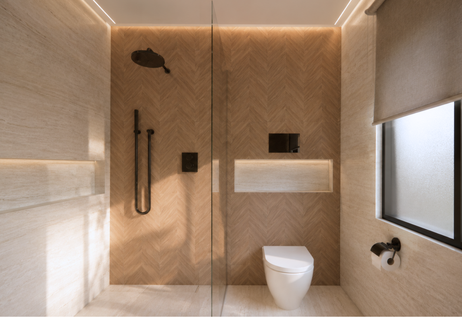 Bathroom with a glass-partitioned shower and wall-hung toilet, a dark rain showerhead and handheld wand, herringbone wood back wall, beige travertine side walls, backlit recessed niches, a frosted window with a roller shade and matte black hardware