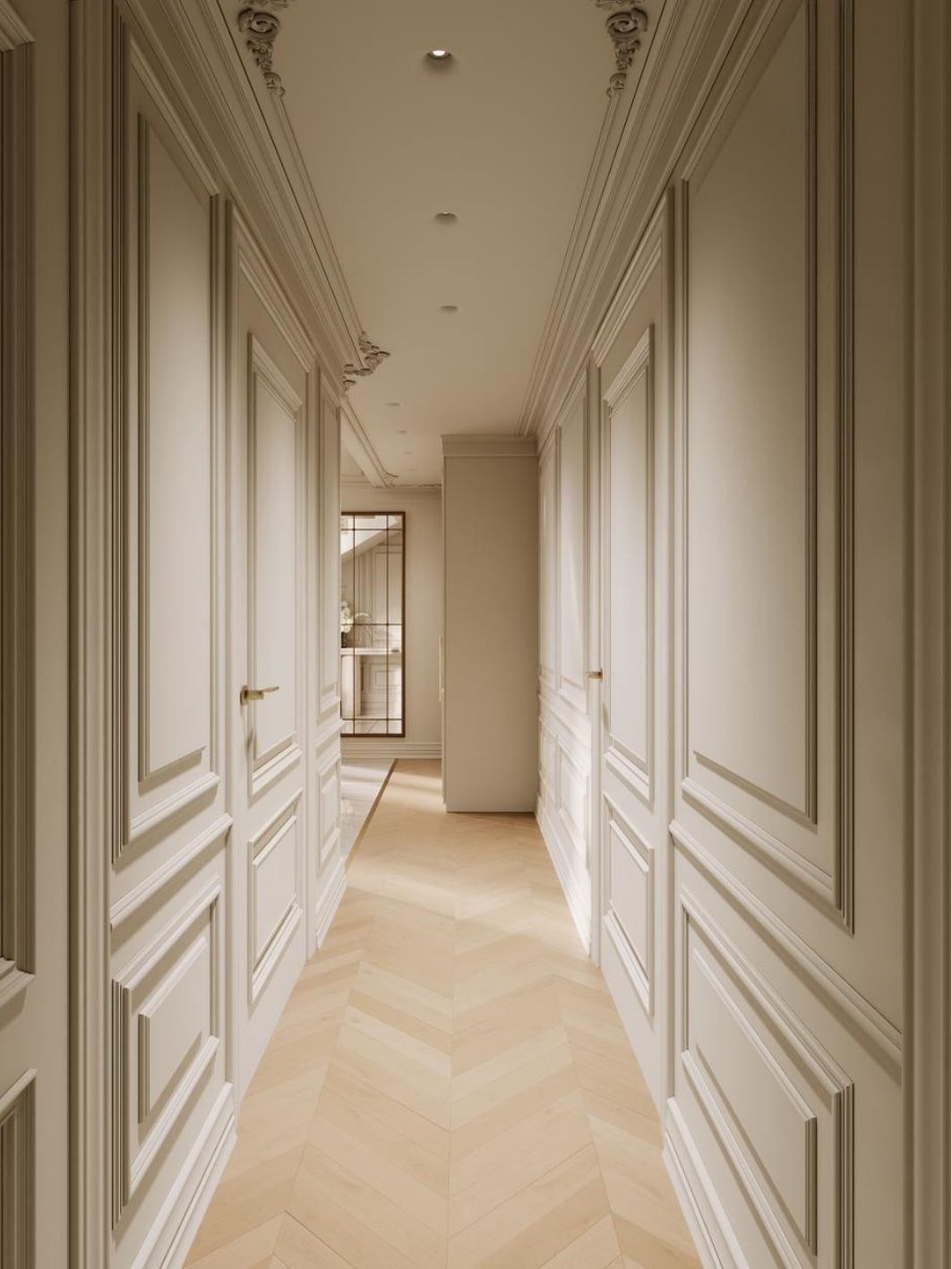 Panelled corridor in soft cream with moulded doors, brass lever handles, carved plaster cornice and pale chevron oak flooring leading to a mirrored opening