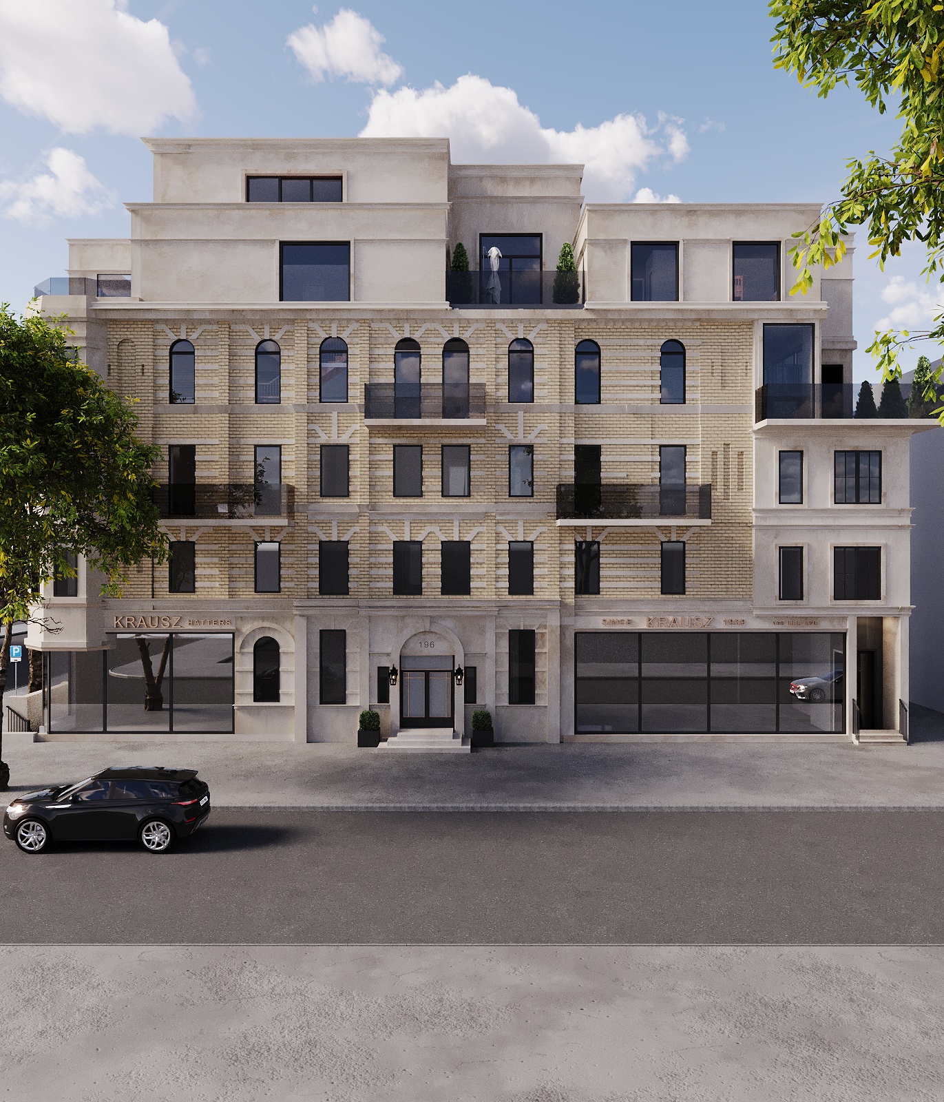 Street-facing elevation in afternoon light with buff brick, cast-stone surrounds and chevron reliefs, arched black-framed windows, planted balconies and full-height glazed shopfronts