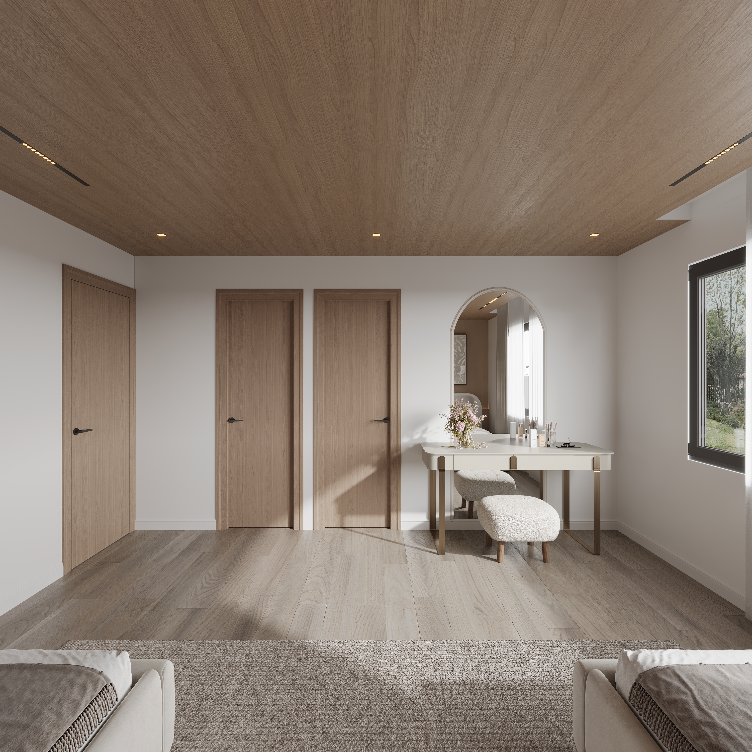 Bedroom looking to a white dressing table with brass legs, boucle stool, arched mirror and flowers, oak veneer doors along the wall and a black-framed window onto trees