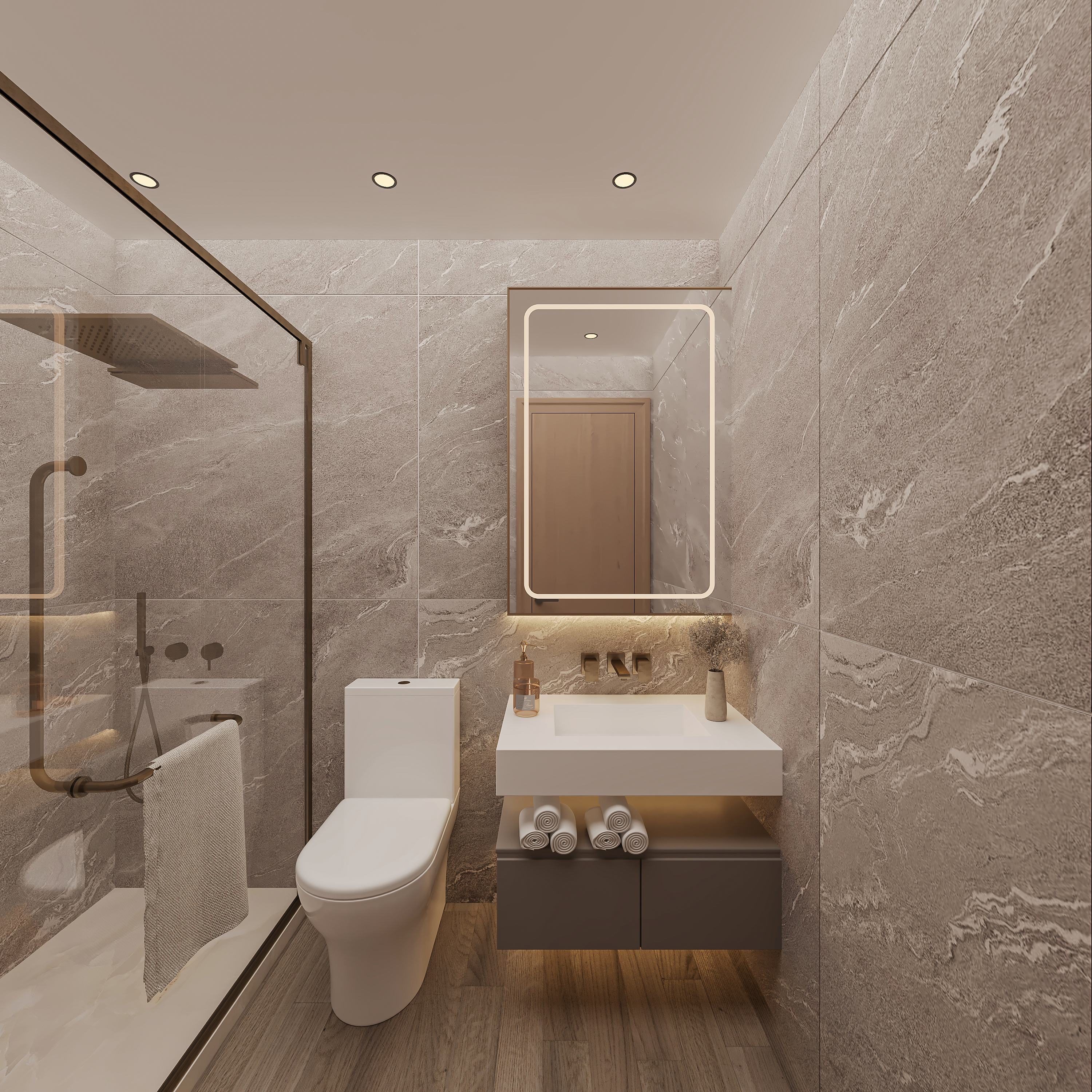 Bathroom lined in grey veined stone with a backlit rectangular mirror, floating white basin on a dark drawer unit with rolled towels, brushed brass wall taps and a glass walk-in shower