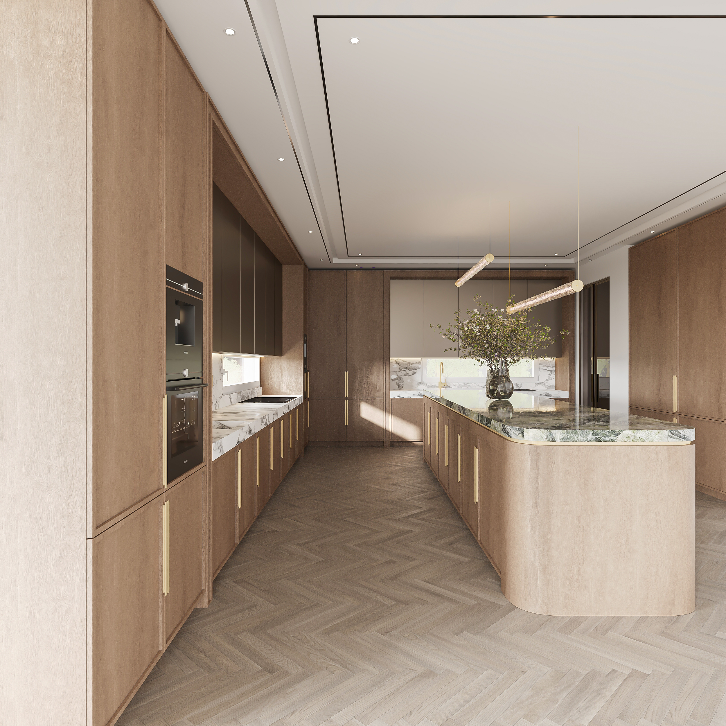 Long view down a pale oak kitchen with full-height cabinetry and slim brass pulls, marble slab backsplash, a curved travertine island with green marble top and linear brass pendants over herringbone flooring