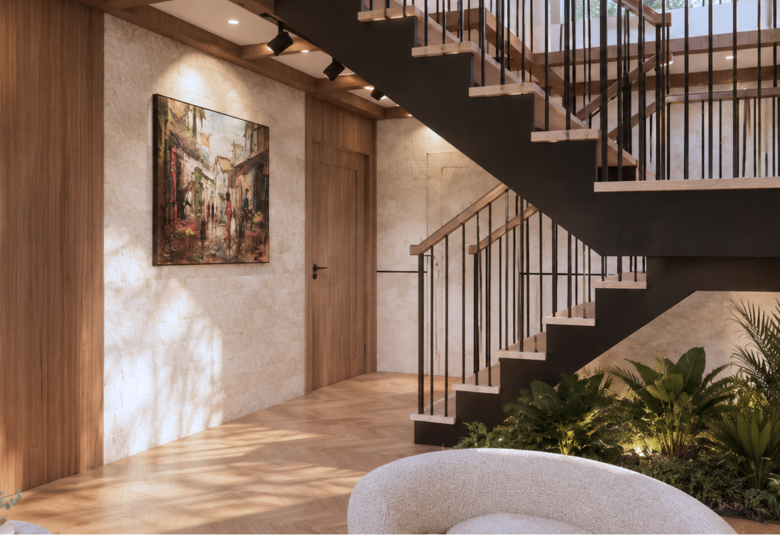 Interior view toward the black steel staircase with wood treads and an indoor garden bed beneath, a cream bouclé armchair in the foreground, a framed street-scene painting on a stone wall and a wood door with patterned sunlight on herringbone oak flooring