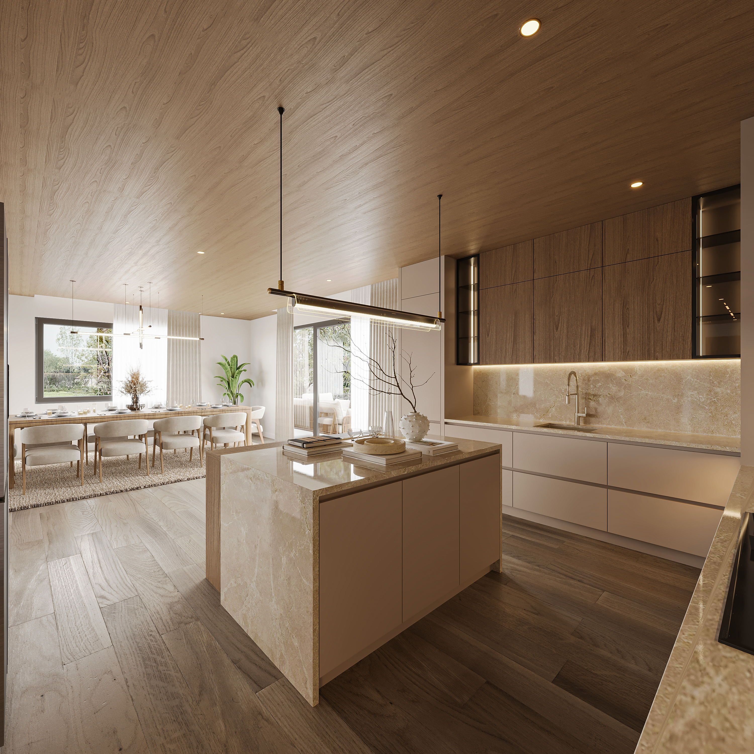 Kitchen open to the dining area under a warm timber ceiling, with a stone island, handleless cream cabinetry, backlit stone splashback and a long dining table by the glazing beyond