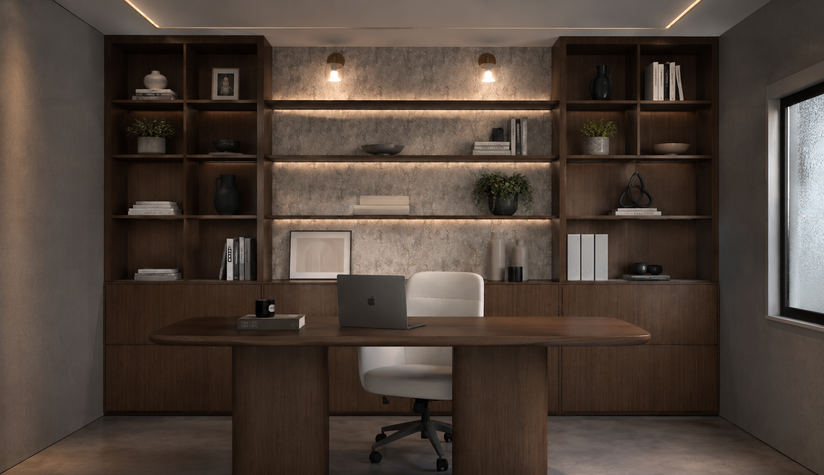 Home office with a solid walnut desk and ivory leather chair, backlit floating shelves against a textured stone panel, walnut display joinery and paired brass downlights