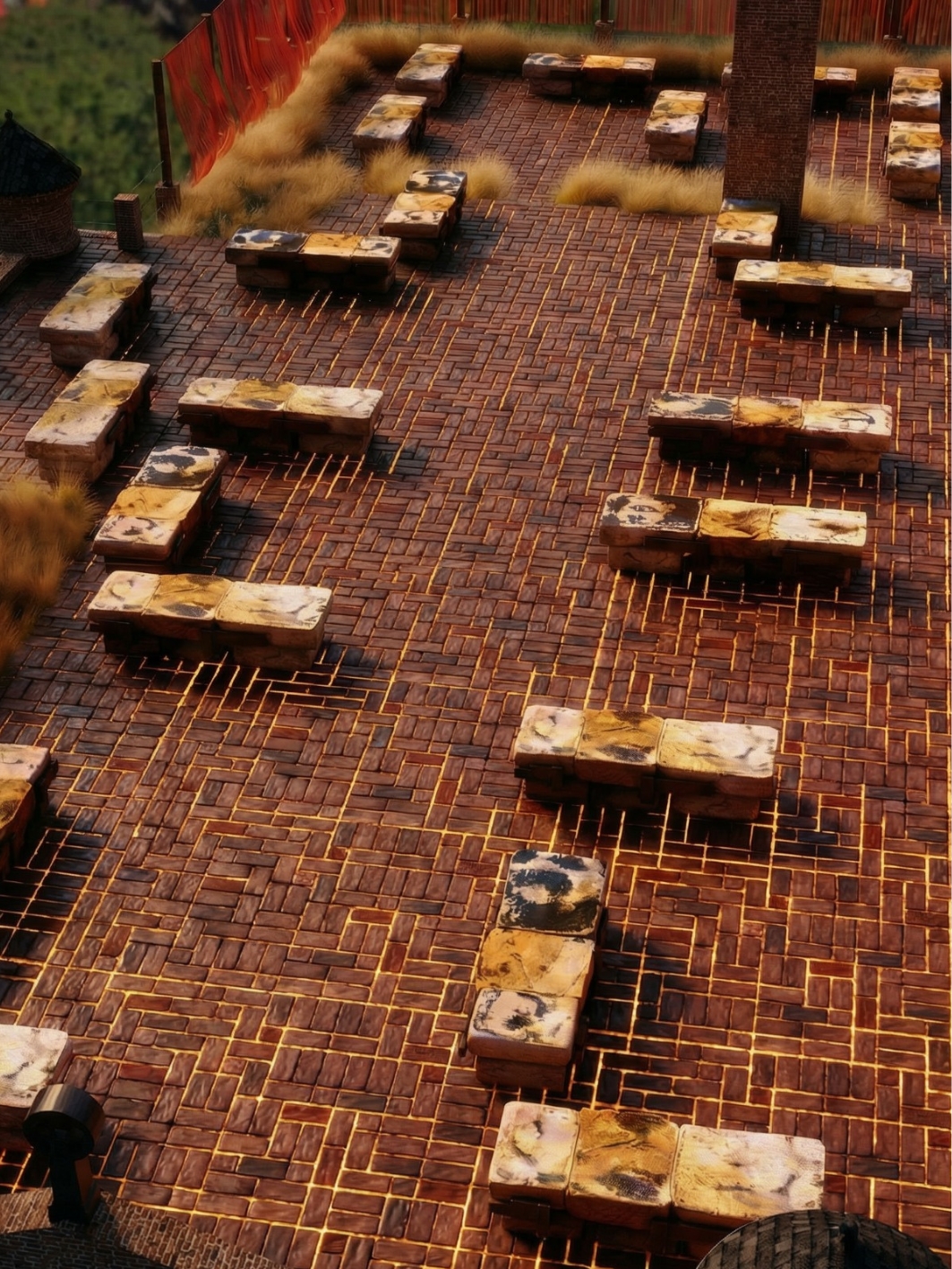 Aerial evening view of the brick terrace with rows of stone-topped benches, glowing light lines set into the paving, a coral screen and dense ornamental grasses