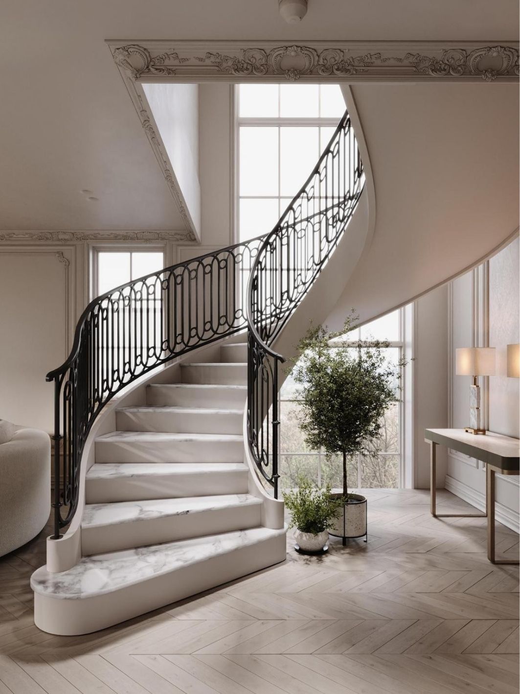 Curved staircase with marble treads and a scrolled black ironwork balustrade, decorative plaster cornice, tall gridded windows, a potted olive tree and pale chevron oak flooring