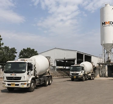 Pátio externo da MMIX com silo e caminhões betoneira