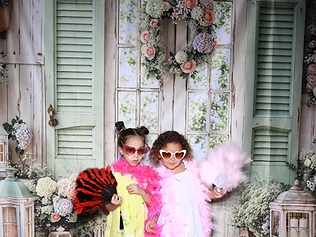 Two girls with feather boas at a GlamBooth garden-themed birthday
