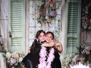 Two girls hugging at a GlamBooth garden-themed birthday