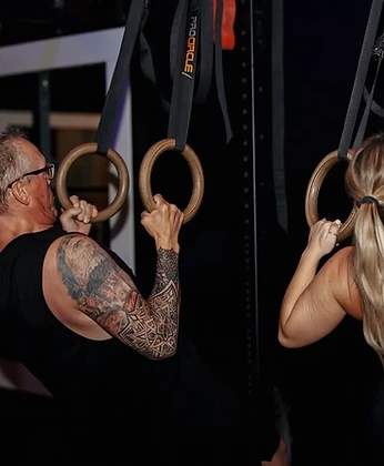 Two members training on gymnastics rings
