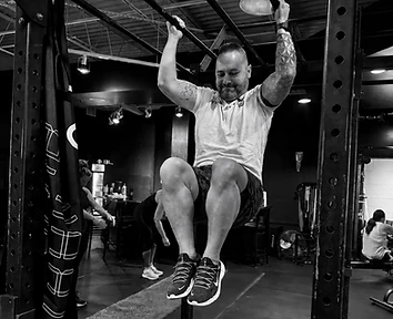 Athlete performing hanging leg raises on the lifting rig at Fitness Mentality
