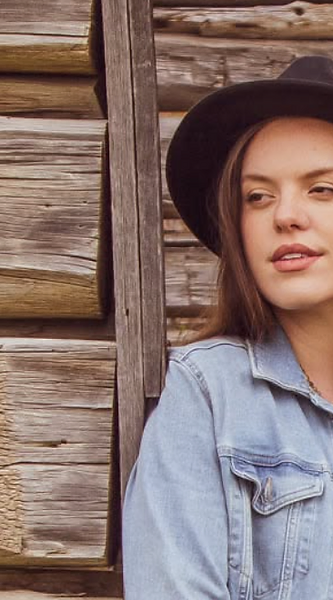 Rebekah Waller in a black fedora and denim jacket