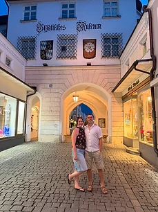 Nathan and a friend arm-in-arm in a cobblestone street at dusk
