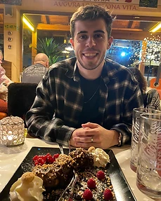 Nathan smiling at a restaurant table with a chocolate dessert