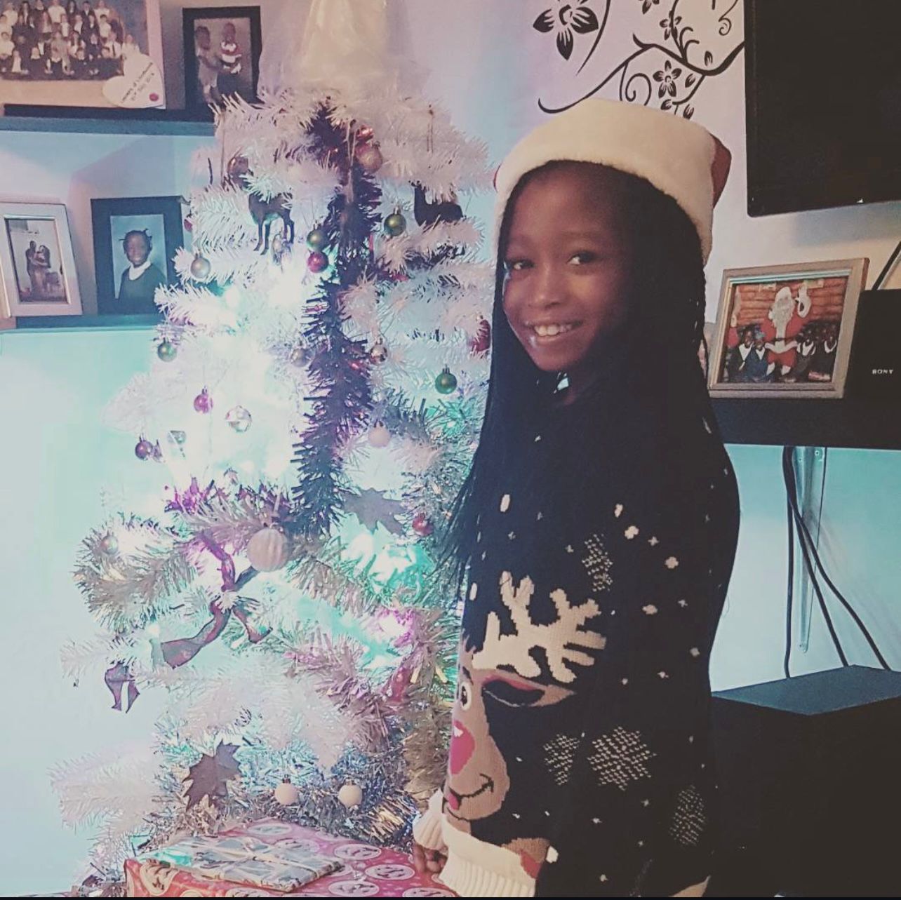 Elizabeth smiling beside a Christmas tree