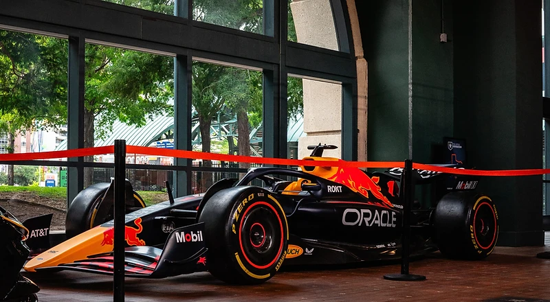 Elite cars displayed under lights at a dramatic venue