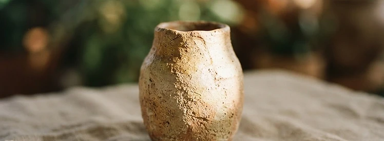 A textured clay vase in soft light