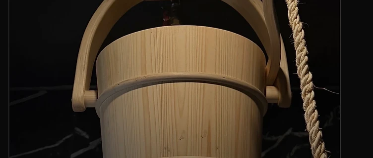 Wooden dump bucket filled with cold water in a dark Nordic spa