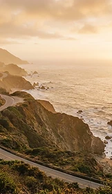 The California Pacific coast at golden hour, cliffs meeting the ocean