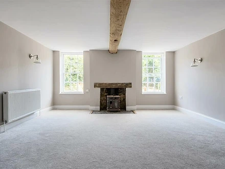 Lounge with wood-burning stove and exposed beam