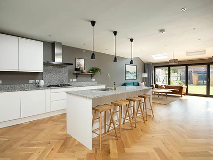 Open-plan kitchen with island and herringbone parquet